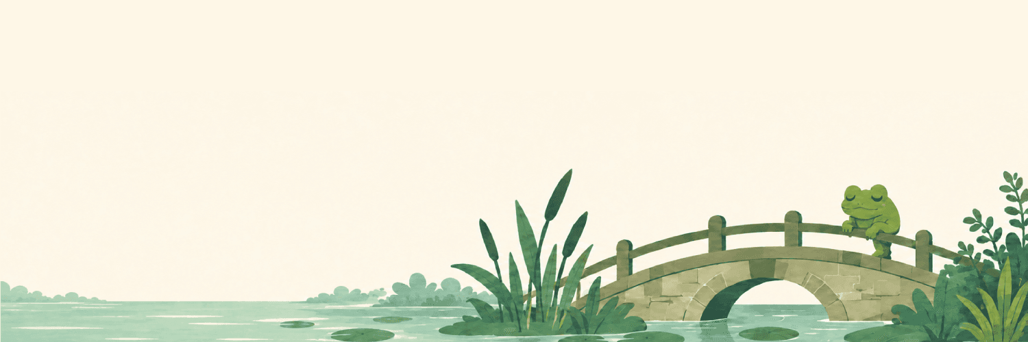 A frog resting on a stone footbridge over a still pond, reeds and lily pads in the water